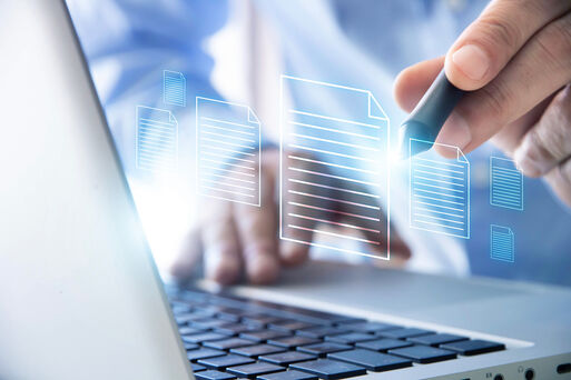 Hande, die auf einem Laptop tippen